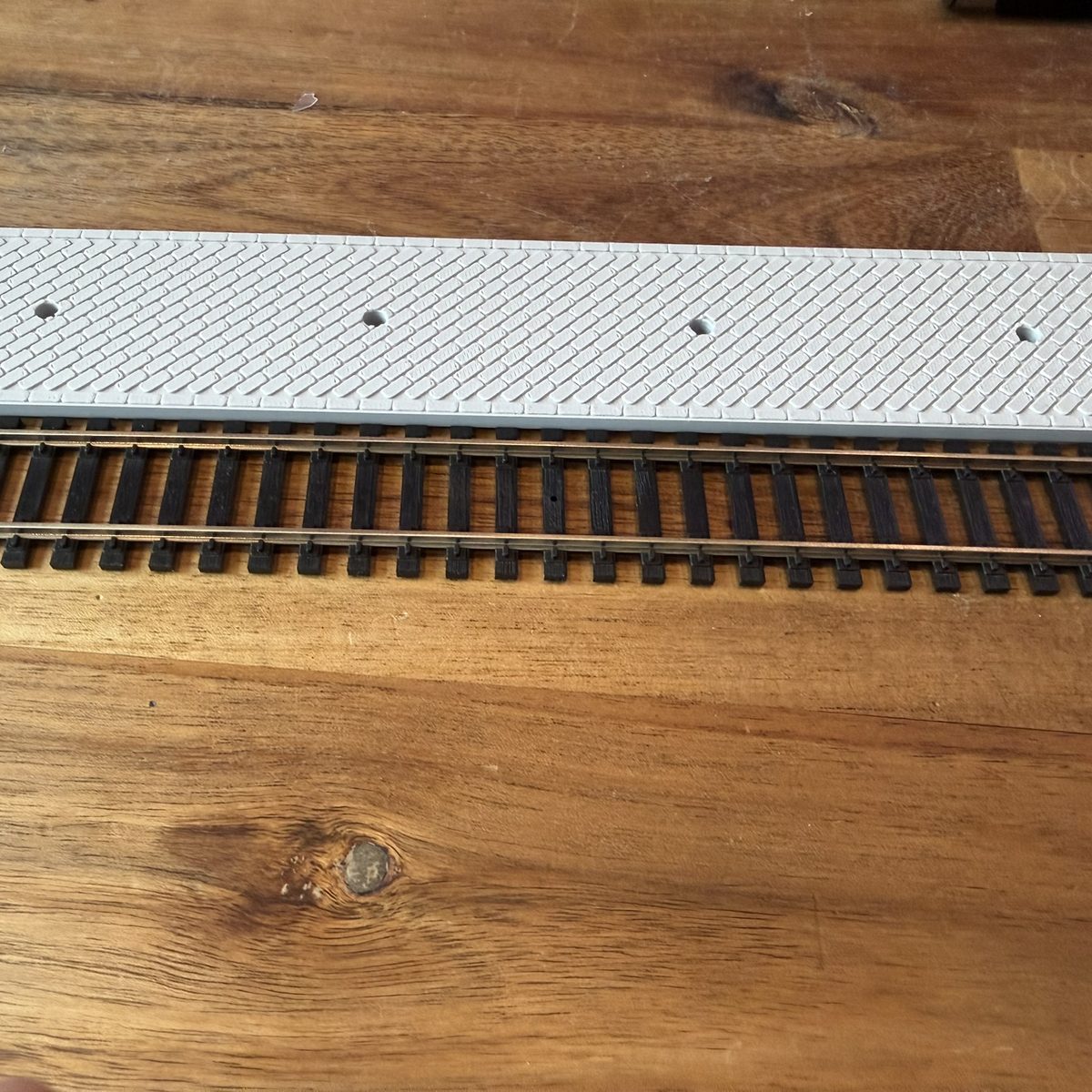 Real print: the platform edge running straight along the Atlas track, deck at rail height
